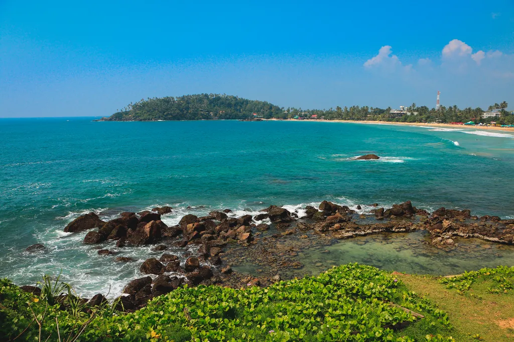 Palm-backed sand curving into turquoise water at Mirissa on Sri Lanka’s south coast