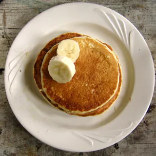 A pancake topped with sliced banana