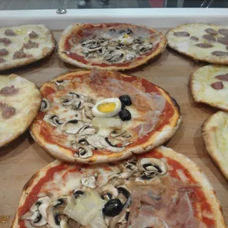 A pizza capricciosa with mushrooms, olives and boiled egg