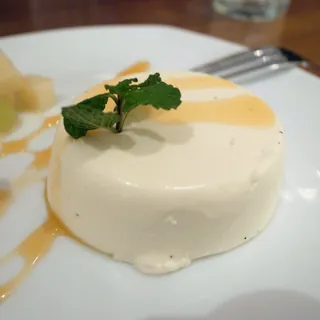 A set panna cotta with cream and a mint garnish