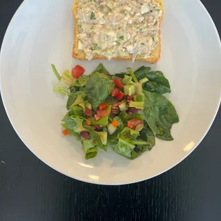 An open tuna sandwich served with salad